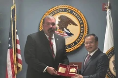 Le vice-ministre de la Sécurité publique Nguyên Van Long remet un souvenir au directeur adjoint par intérim de la Division des programmes correctionnels du Bureau fédéral américain des prisons, Shane Salem. Photo : VNA
