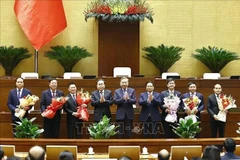 Le secrétaire général du Parti Tô Lâm (centre), le Premier ministre Pham Minh Chinh et le président de l’Assemblée nationale Trân Thanh Mân félicitent les personnels élus, nommés. Photo: VNA