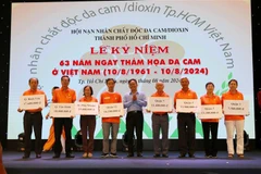 Des responsables du Front de la Patrie du Vietnam à Hô Chi Minh-Ville remettent des bourses d'études aux représentants des enfants victimes de l’agent orange. Photo: VNA 