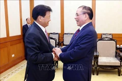 Le SG du PPRL et président lao Thongloun Sisoulith (gauche) et l’ancien SG du PCV Nong Duc Manh. Photo: VNA