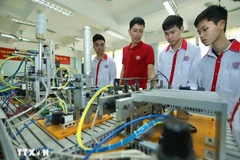 Présentation de modèles d'automatisation aux étudiants de la classe d'électronique industrielle K13 du Collège professionnel de haute technologie de Hanoi. Photo : Hoang Hieu/VNA