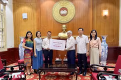 Le 27 septembre, au siège du Comité central du Front de la Patrie à Hanoï, Tang Tuan Tu ( gauche), président de l'Association vietnamienne au Royaume-Uni a remis 100 millions de dongs pour soutenir la population sinistrée. Photo : VNA