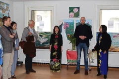 La peintre Kim Doan (au milieu) au vernissage de son exposition à Bruxelles. Photo: VNA