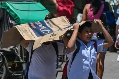 Des étudiants utilisent un carton pour se protéger du soleil lors d'une chaude journée à Manille le 2 avril 2024. (Photo : philstar.com)