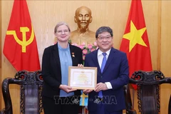 L'ambassadrice de Suède au Vietnam reçoit un insigne pour sa contribution à l'enseignement de la théorie politique. Photo : VNA