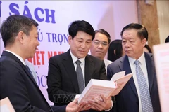 Luong Cuong, membre du Bureau politique, permanent du Secrétariat (centre) et Nguyen Trong Nghia, membre du Bureau politique, secrétaire du Comité central du Parti et chef de la Commission centrale de propagande et d'éducation (droite) lors de la zone d'exposition de livres. Photo : VNA