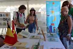 Des visiteurs s'intéressent au livre du feu secrétaire général du Parti Nguyen Phu Trong sur la théorie et la pratique de la voie vers le socialisme au Vietnam. Photo : VNA