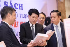 Luong Cuong, membre du Bureau politique, permanent du Secrétariat (centre) et Nguyen Trong Nghia, membre du Bureau politique, secrétaire du Comité central du Parti et chef de la Commission centrale de propagande et d'éducation (droite) lors de la zone d'exposition de livres. Photo : VNA
