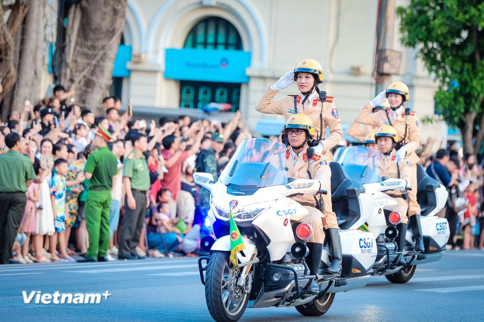 Des agentes de la police de la circulation saluent en formation. Photo : VNA