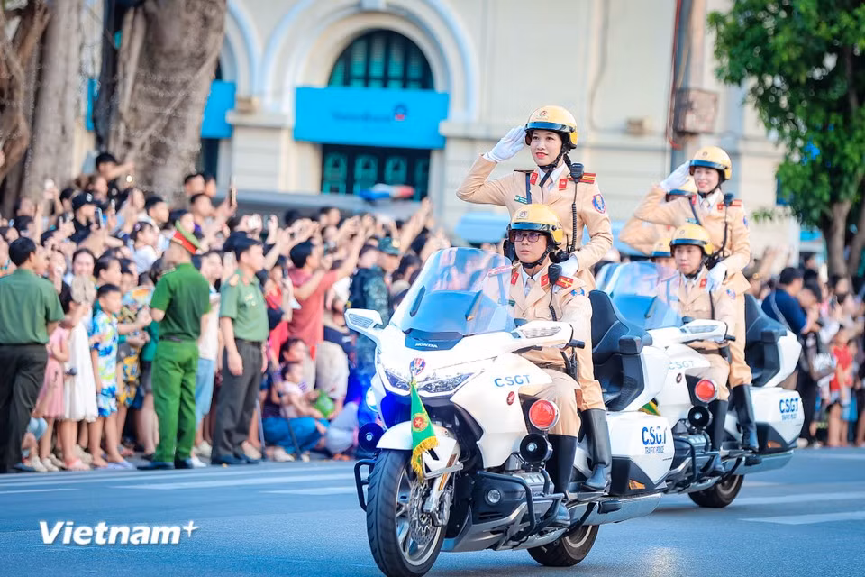 Des agentes de la police de la circulation saluent en formation. Photo : VNA