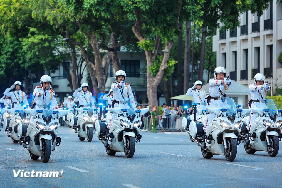 Les policiers exécutent des techniques de conduite avancées, telles que le salut et le tir, tout en gardant le contrôle de leur moto. Photo : VNA