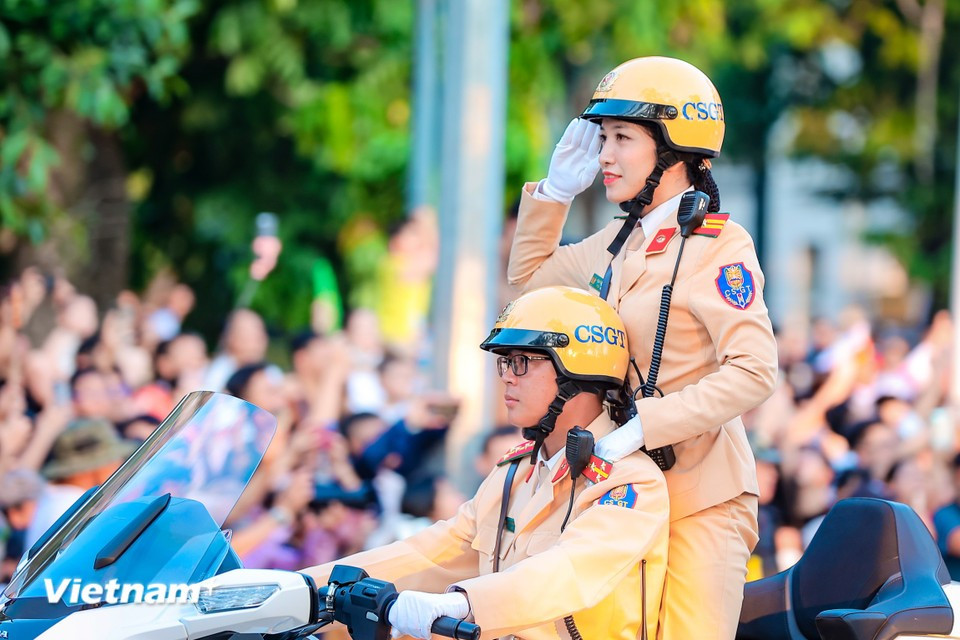 Une agente de la police de la circulation salue avec élégance au sein de la formation. Photo : VNA