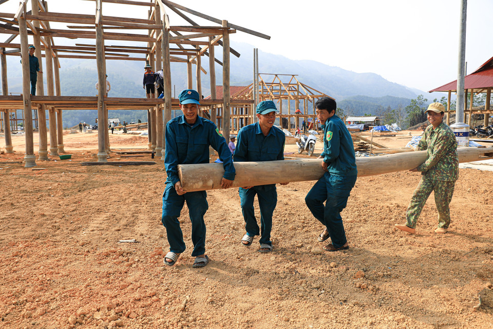 Des membres des milices locales apportent leur aide aux habitants du village de Muong Pôn 2 en reconstruisant leurs maisons traditionnelles sur pilotis. Photo: VNA