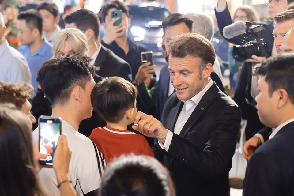 Le président français, Emmanuel Macron, et sa première dame rencontrent des habitants lors d'une promenade dans le Vieux Quartier de Hanoï, le soir du 26 mai. Photo: VNA