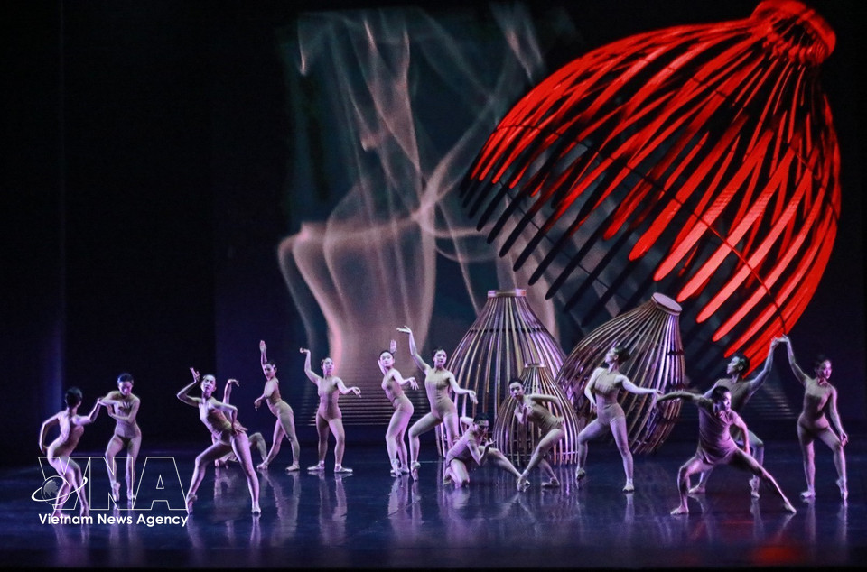 Sur scène, une vingtaine de danseurs réinterprètent des gestes du quotidien - jeter un filet, poser une nasse, porter de l’eau, repiquer le riz - transformés en un langage chorégraphique abstrait. Photo: VNA