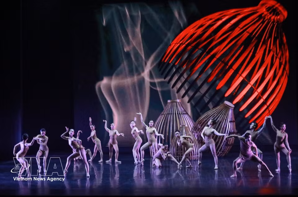Sur scène, une vingtaine de danseurs réinterprètent des gestes du quotidien - jeter un filet, poser une nasse, porter de l’eau, repiquer le riz - transformés en un langage chorégraphique abstrait. Photo: VNA