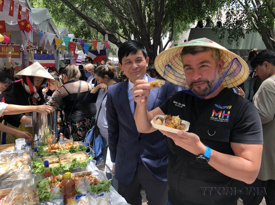 Tabe Echartea, président de l'arondissementde Mauricio (Mexique), déguste des rouleaux de printemps vietnamiens (nem) lors du Festival culturel et culinaire ASEAN+3 Bazaar, à l'occasion du 55e anniversaire de la fondation de l'ASEAN, le 8 août 2022. Photo: VNA