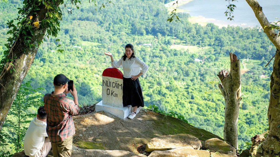 Des touristes posent devant la nature majestueuse de la commune de Nui Câm, province d'An Giang. Photo: VNA