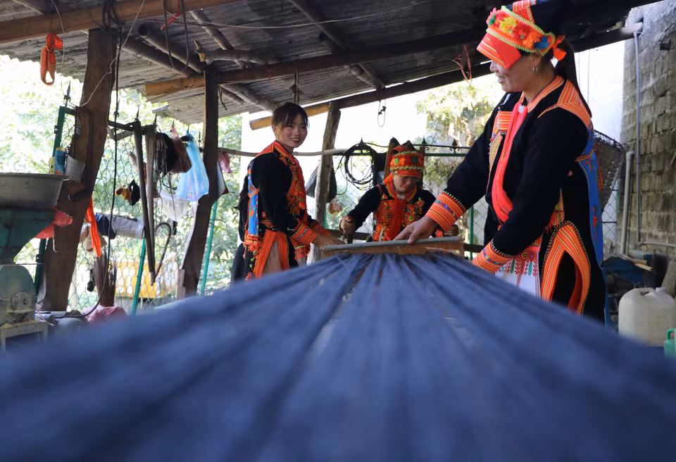 Les fils noirs chatoyants créent les vêtements caractéristiques des femmes Dao. Photo: VNA