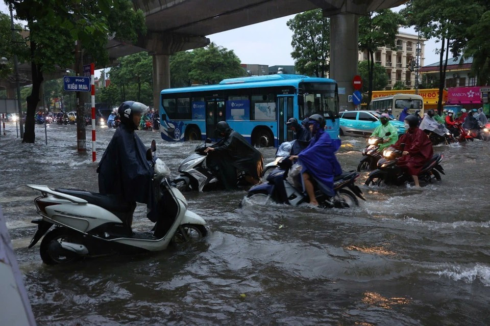 Les habitants peinent à se rendre au travail dans les rues inondées. Photo : VNA
