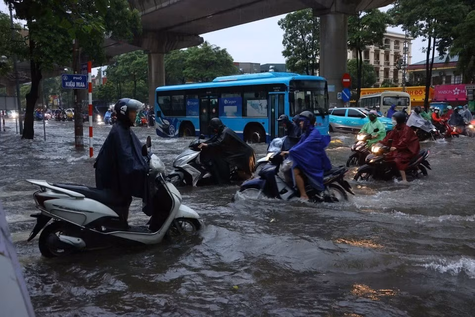 Les habitants peinent à se rendre au travail dans les rues inondées. Photo : VNA