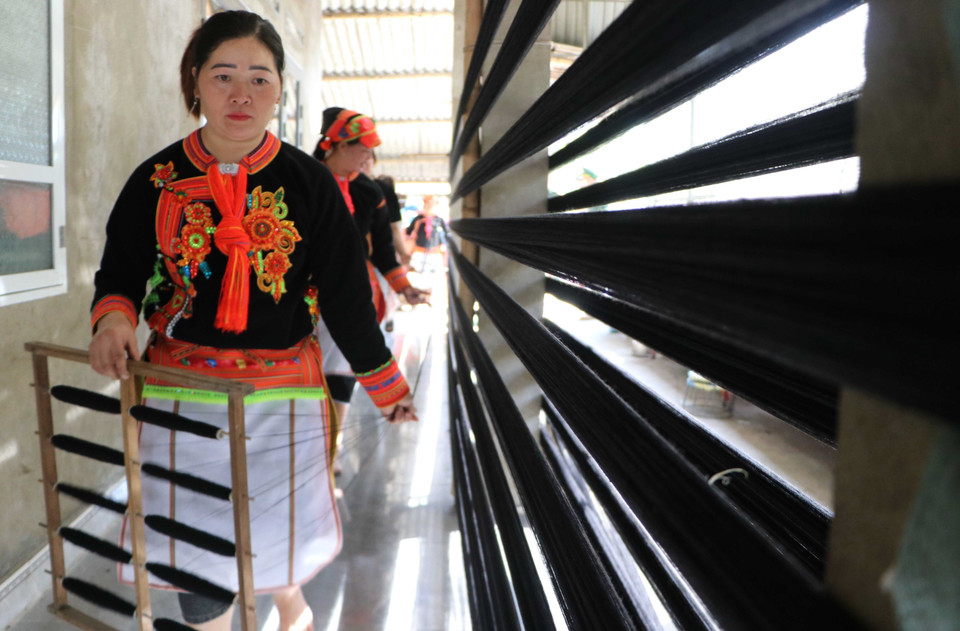 Des femmes Dao du village de Hung Peng, dans la commune de Phong Tho filent le fil pour confectionner leurs costumes traditionnels. Photo: VNA
