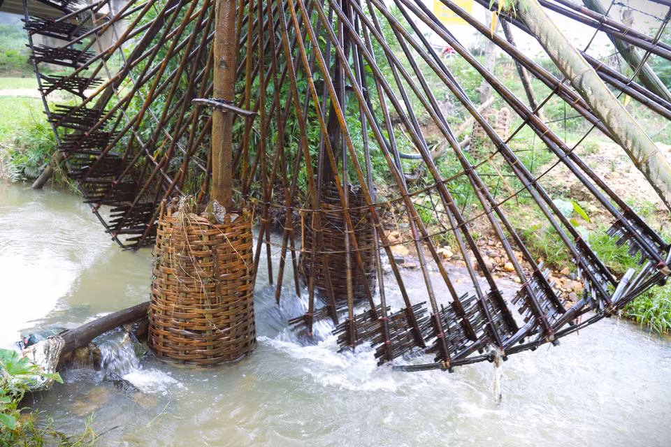 Le poids de la noria repose sur un système de piliers de soutien dont les fondations sont profondément ancrées dans le lit du ruisseau. Afin de renforcer la stabilité de l’ensemble, des pierres sont soigneusement disposées dans des gabions en bambou tressé, permettant de consolider la structure et de maintenir en permanence le pilier central ainsi que la roue de la noria parfaitement à la verticale. Photo : VNA