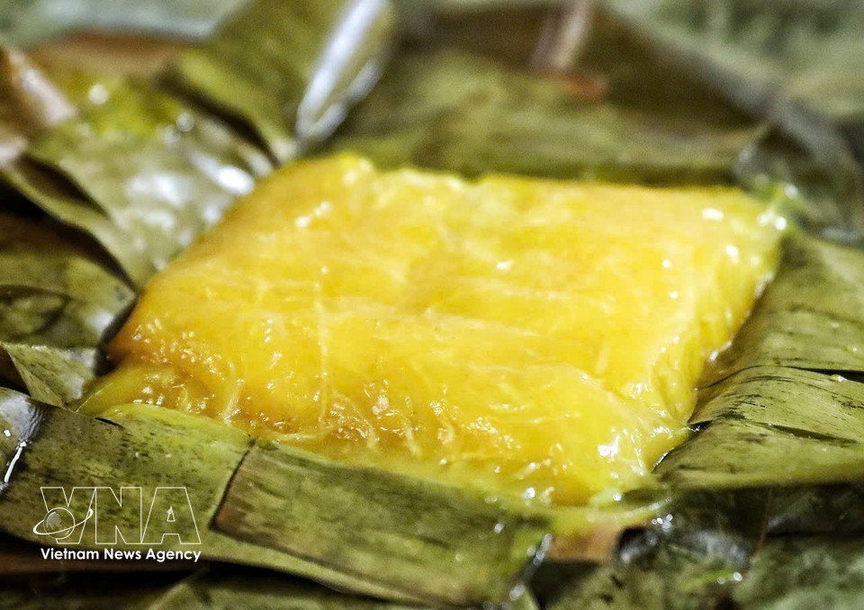 Sa teinte ambrée et translucide cache une garniture parfumée de haricot mungo, de papaye verte et de sucre, délicatement enveloppée dans des feuilles de bananier. Photo: VNA