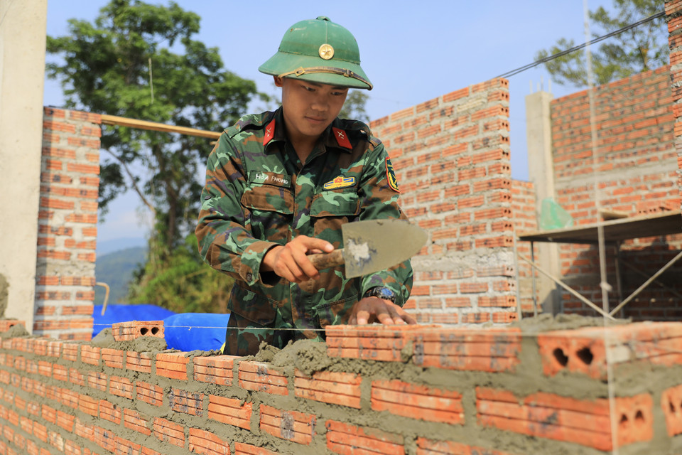 Solidarité en action : les forces du régiment 741 unissent leurs efforts à ceux des habitants de Muong Pôn 2 pour rebâtir leurs vies, brique après brique. Photo: VNA