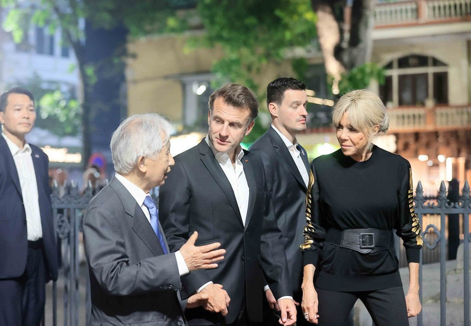 Le président français et son épouse écoutent une présentation sur le Vieux Quartier de Hanoï. Photo: VNA