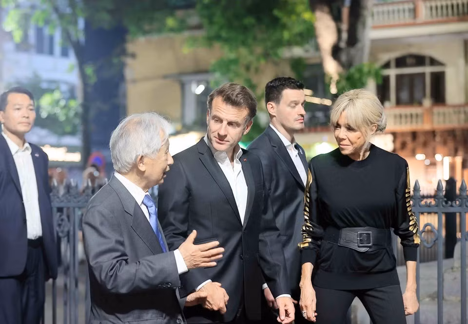 Le président français et son épouse écoutent une présentation sur le Vieux Quartier de Hanoï. Photo: VNA