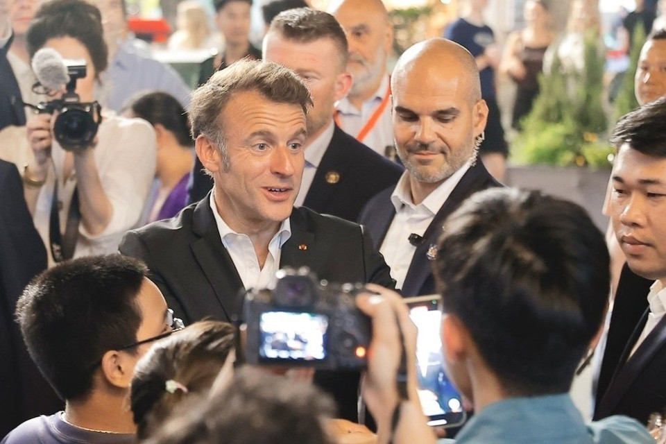 Le président français, Emmanuel Macron, et sa première dame rencontrent les habitants lors d'une promenade dans le Vieux Quartier de Hanoï, le soir du 26 mai. Photo: VNA