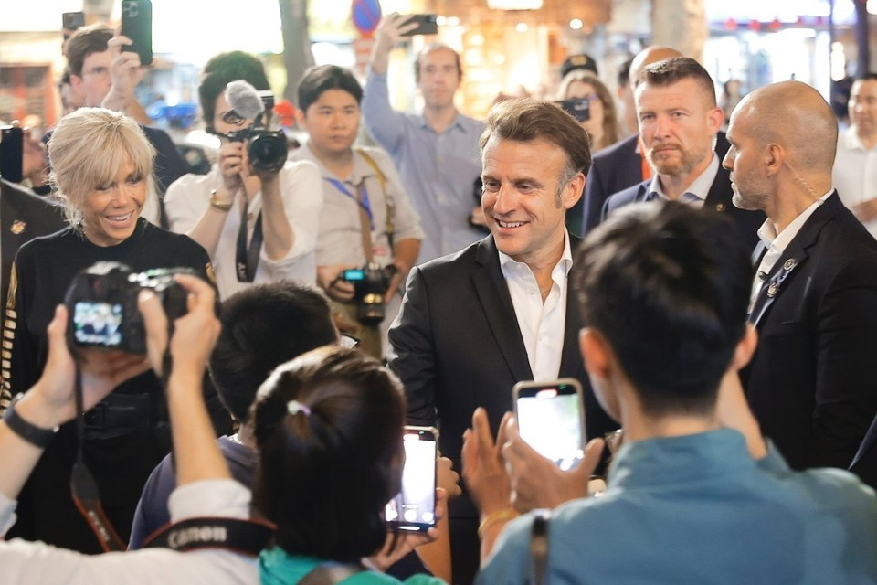 Le président français, Emmanuel Macron, et sa première dame rencontrent des habitants lors d'une promenade dans le Vieux Quartier de Hanoï, le soir du 26 mai. Photo: VNA