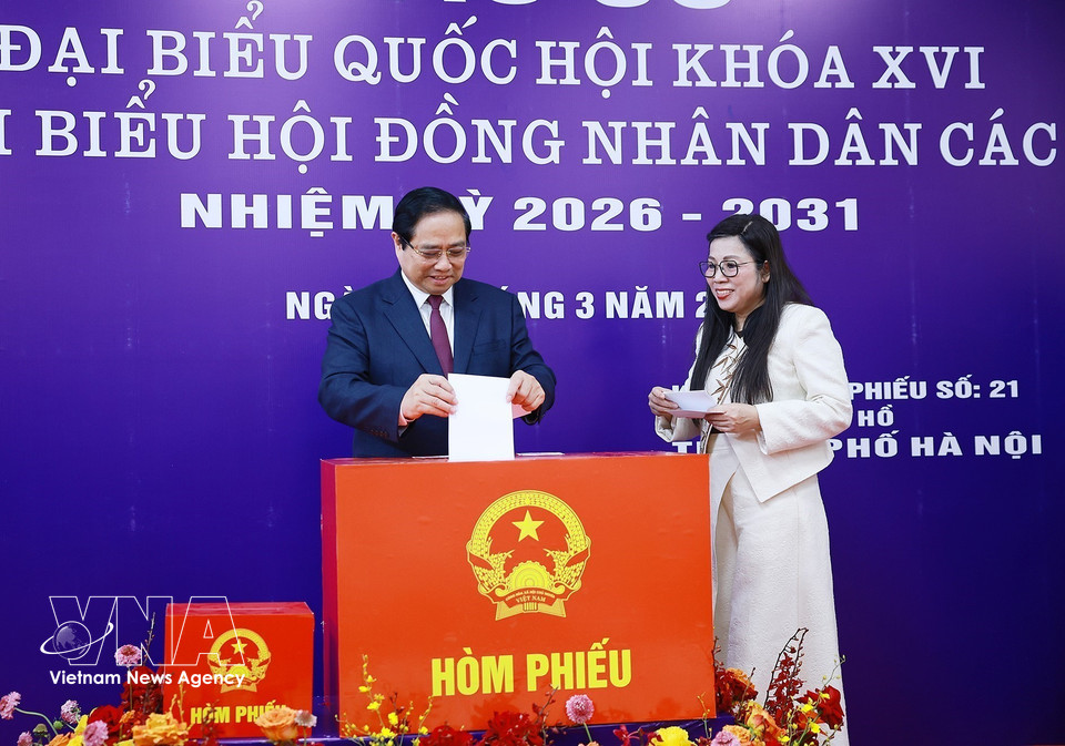 Le Premier ministre Pham Minh Chinh et son épouse déposent leurs bulletins de vote dans l'urne. Photo: VNA