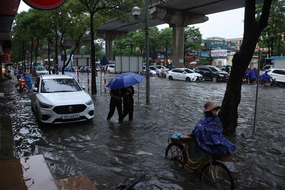 La rue Câu Diên est fortement inondée, rendant les déplacements des habitants particulièrement difficiles dans la matinée du 7 octobre. Photo : VNA