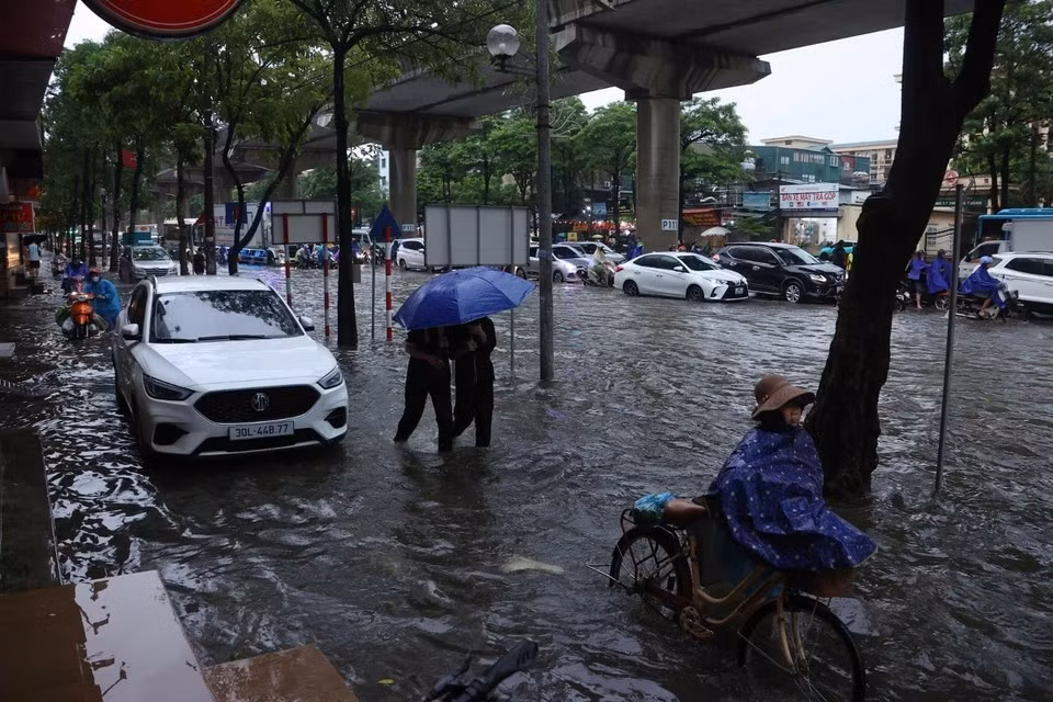 La rue Câu Diên est fortement inondée, rendant les déplacements des habitants particulièrement difficiles dans la matinée du 7 octobre. Photo : VNA