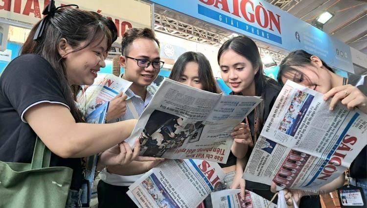 Des lecteurs découvrent un journal du Parti âgé de 49 ans à Hô Chi Minh-Ville, lors du Salon national de la presse 2024. Photo : VNA