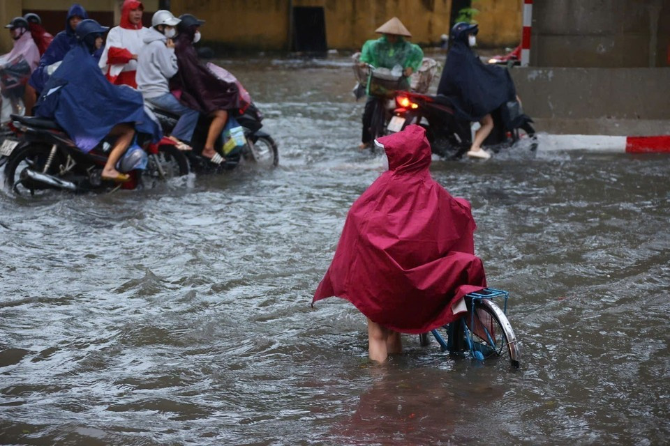 La rue Câu Diên est fortement inondée, rendant les déplacements des habitants particulièrement difficiles dans la matinée du 7 octobre. Photo : VNA