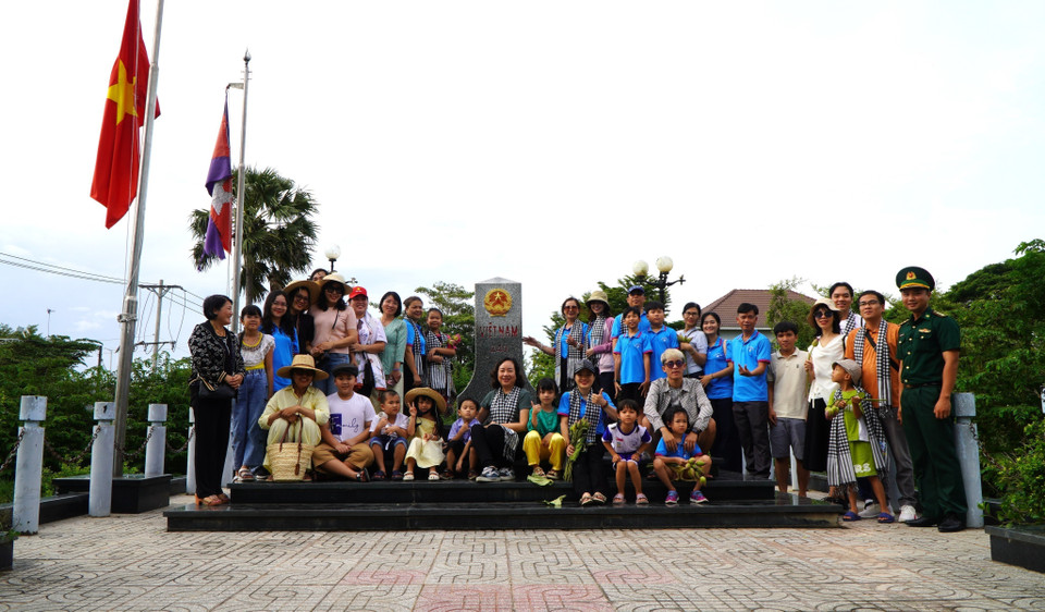 Après découvrir des champs innondées, des touristes peuvent visiter la borne frontière nationale au poste-frontière international de Thuong Phuoc . Photo: VNA
