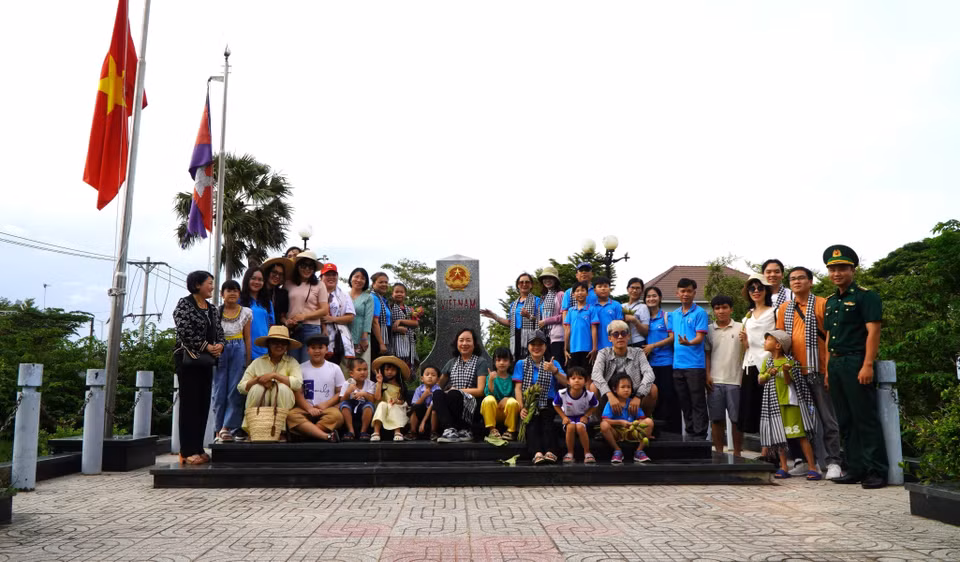 Après découvrir des champs innondées, des touristes peuvent visiter la borne frontière nationale au poste-frontière international de Thuong Phuoc . Photo: VNA