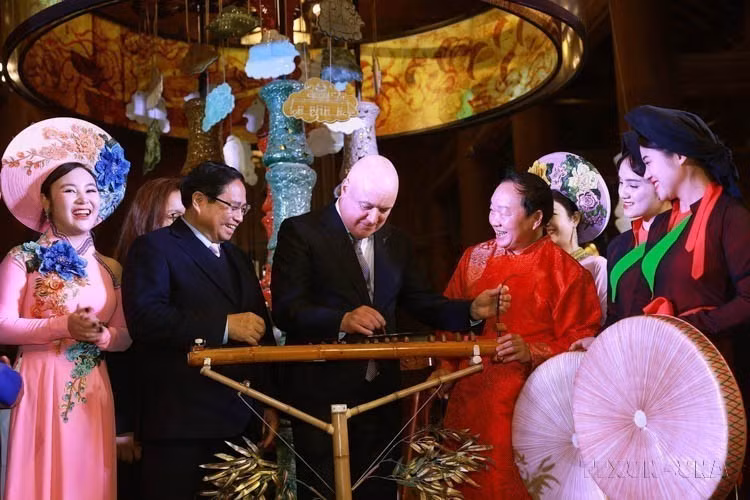 Le Premier ministre néo-zélandais, Christopher Luxon, découvre des instruments de musique traditionnels vietnamiens lors de sa visite au Temple de la Littérature à Hanoï, en compagnie de son homologue vietnamien Pham Minh Chinh, le 27 février 2025. Photo: VNA