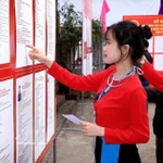 Une électrice de l’ethnie Muong, votant pour la première fois, examine attentivement la biographie des candidats. Photo: VNA