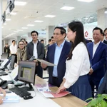 Le Premier ministre Pham Minh Chinh (en chemise bleue) visite le Centre de services administratifs publics de Quang Ninh. Photo: VNA