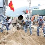 70 soldats sont mobilisés simultanément sur les quatre bâtisses afin de reconstruire les habitations détruites par les inondations. Photo: VNA