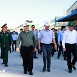 Le Premier ministre Pham Minh Chinh (chemise grise) visite des sites de production endommagés par le typhon Kalmaegi dans la zone économique de Nhon Hoi. Photo : VNA