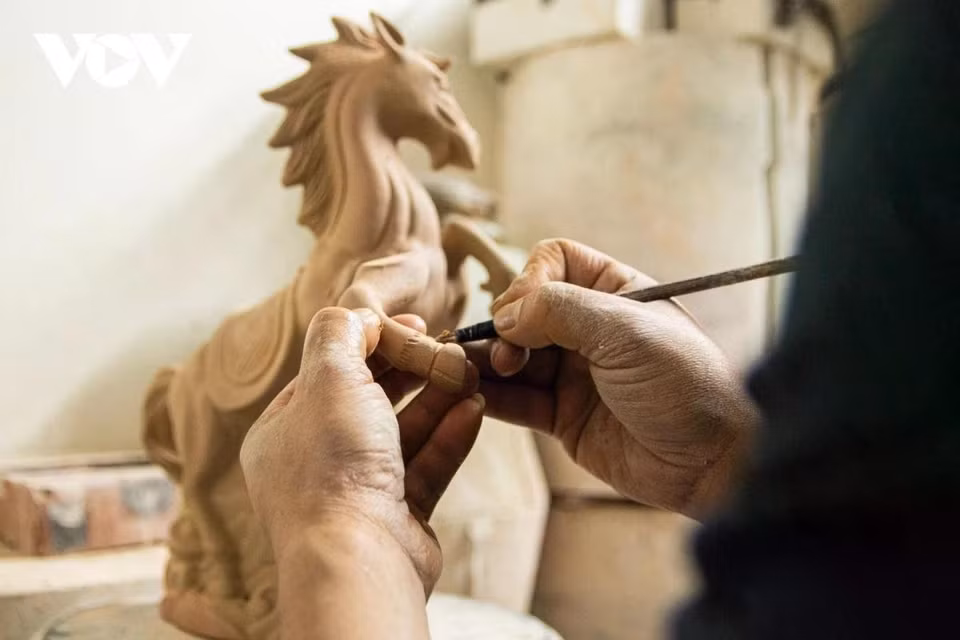 L’artisan ne se contente pas de façonner les figurines, il leur insuffle la vie. Il dessine des motifs sur la surface, un processus extrêmement méticuleux et précis qui constitue l’étape finale de la définition de la valeur esthétique du produit avant sa commercialisation. Photo :VOV