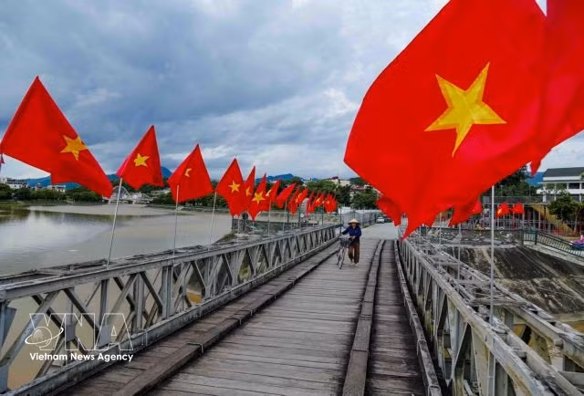 Le drapeau national flotte au-dessus du pont de Muong Thanh, un lieu emblématique associé aux événements historiques de la campagne de Diên Biên Phu.