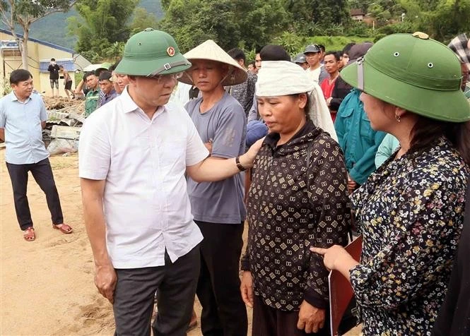 Le vice-Premier ministre Le Thanh Long et des sinistrés à Chieng So. Photo: VNA