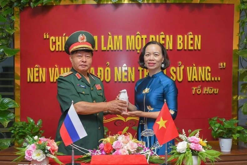 Le général Luu Trong Lu, président de l’Association des anciens combattants de la province de Diên Biên, remet l’urne contenant la terre sacrée à Vu Thi Tuyet Nga, directrice du Musée de la Victoire de Diên Biên Phu. Photo : VNA