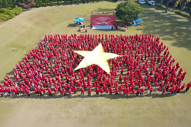 Plus d'un millier de Vietnamiens forment ensemble le Drapeau rouge à l’étoile d’or. Photo: VNA